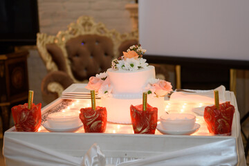 A large festive cake is on the table. A delicious dessert at a party.