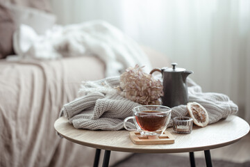 Autumn home composition with a cup of tea, a teapot and a knitted element.
