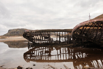 a broken wooden ship near the shore