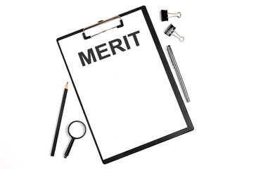 On a white background magnifier, a pen and a sheet of paper with the text MERIT Business concept