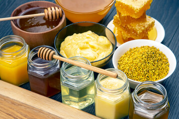 Fresh flower honey of different varieties, pollen and honeycomb with spoons on a wooden background. Organic Vitamin Health Food