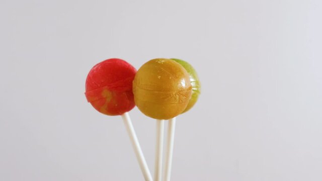 Three lolipop candies spinning on a white background, background from sweets..