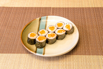 Eight servings of sushi maki roll stuffed with Japanese rice with vinegar and Norwegian orange salmon rolled with nori seaweed, wasabi and ginseng