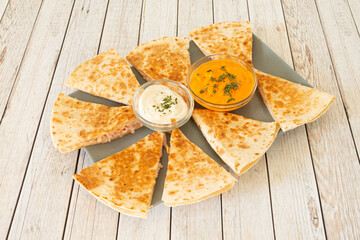 Synchronized shredded chicken quesadillas with cream cheese and cheddar cheese with chopped parsley