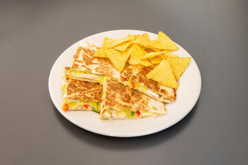 Mexican fried chicken quesadillas with vegetables and melted cheese and corn chips