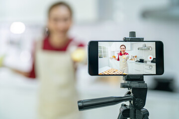 Asian woman bakery shop owner using smartphone with internet presentation sweet dessert bakery on...