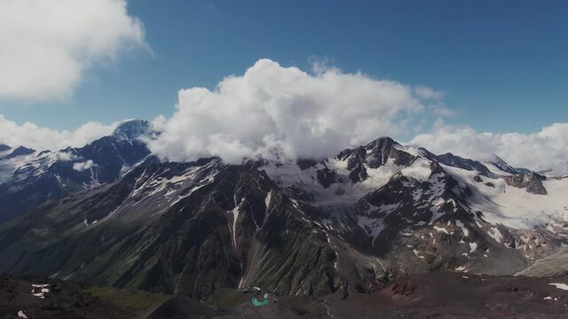 Snow-capped top of Mount Elbrus with peeking rocky ledges