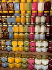 There are many jars of organic, natural honey on the counter for sale. Different honey, different colors in plastic cans are ready for sale at the honey fair. Nuts filled with honey. 