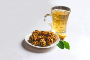 cup of green tea with walnuts and lemon leaves