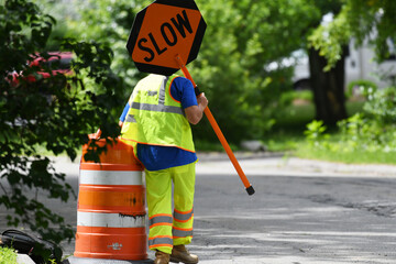 outdoor worker hold slow sign at road construction site