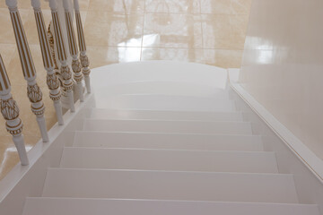 carved wooden staircase with white paint and gold finish