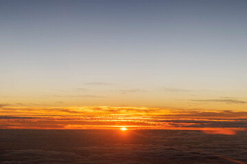 Fototapeta na wymiar An aerial view of the sky where the sun is rising above the clouds shining in the morning light is an aerial view of the plane journey.