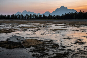 Obraz premium View of silhouetted mountains and trees in Grand Teton National Park, Wyoming during sunset. 