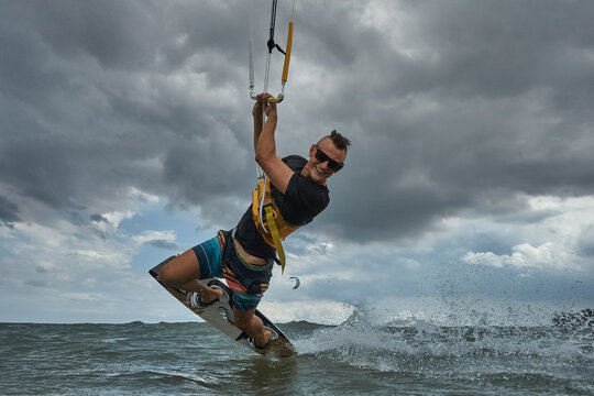 Kite surfer riding a kiteboard on the sea with splash