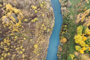 aerial top down view of small river in swampy area. autumn nature scenery from wilderness.