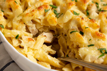 Homemade Chicken Alfredo Pasta Bake with Parsley, side view. Close-up.