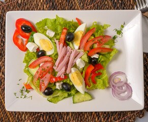 Fresh bulgarian salad with vegetables, tomatoes, onion, olives, boiled eggs, cheese and bacon. Salata bulgareasca traditionala