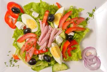 Fresh bulgarian salad with vegetables, tomatoes, onion, olives, boiled eggs, cheese and bacon. Salata bulgareasca traditionala