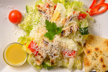 Healthy grilled chicken Caesar salad with vegetables, tomatoes, chicken breast, boiled eggs, parmesan cheese. North American cuisine