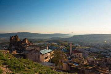 トルコ　カッパドキアのウチヒサール城から見える奇岩群とギョレメ国立公園の早朝の空を飛ぶ熱気球