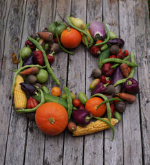 Naklejka na ściany i meble Autumn wreath of vegetables on a wooden background.