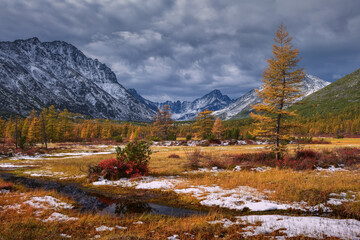 The first snow in the valley of the mountains on an autumn sunny day