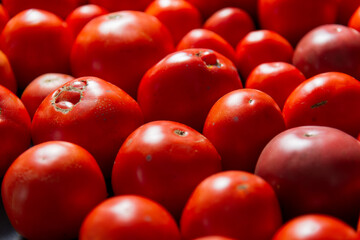 Dark background, a lot of tomatoes are laid out in different shapes.