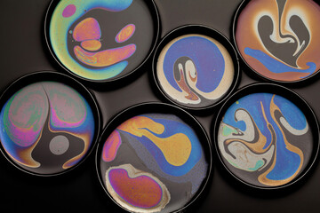 beauty of a thin film of oil in dish on black background.