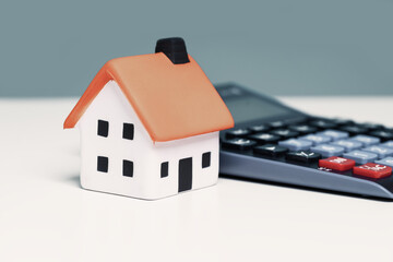 mortgage calculator or real estate business concept. Office desk with house and calculator and copy...