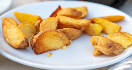 Fried potatoes in a plate on a table