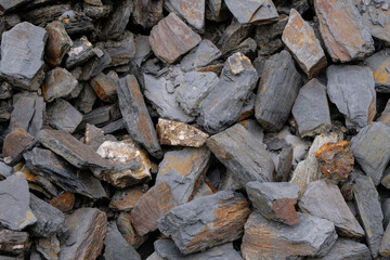Slate striped stone for design. Dark gray stones with rusty spots.
