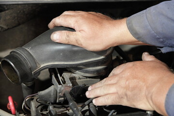 Old car engine air filter check - service man hands holding the air filter box on mono injector fuel system unit closeup, motor repair service