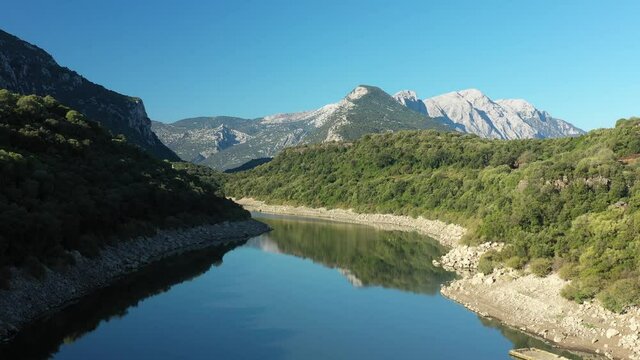 View from above, stunning aerial view of the Cedrino Lake - Lago del Cedrino, surrounded by the mountain range of Supramonte located northeast of the Gennargentu massif. Sardinia, Italy.