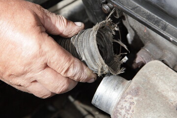Air heating for an automobile engine intake - a man's hand with a pipe of the heat shield of the...