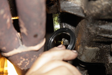 Car driveshaft sealing ring change, gear box repair when oil leak, view under bottom of old front...
