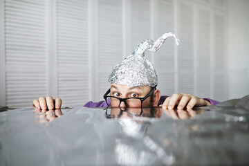 Bearded funny man in a cap of aluminum foil. Concept art phobias.Conspiracy theory. Conspiracy....