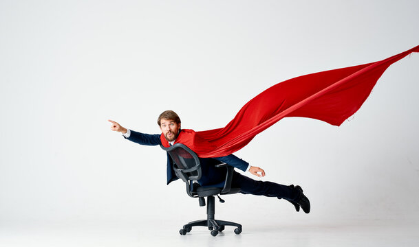 a man in a red cloak suit ride in a chair superheroes