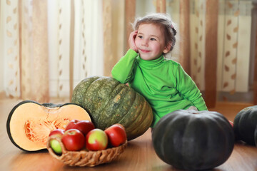 Fototapeta na wymiar Little child choose a pumpkin at autumn. Child sitting on giant pumpkin. Pumpkin is traditional vegetable used on American holidays - Halloween and Thanksgiving Day.