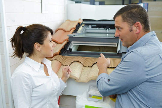 Sales Assistant Showing Roof Lights To Customer