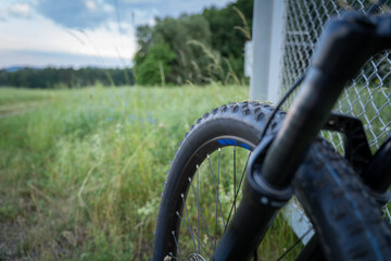 Black mountain bike wheel with suspension fork on the meadow 