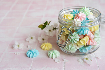 Small colorful meringues in the glass jar