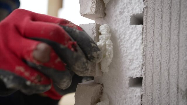 The master glues the tiles to the facade of the building. Decorative tiles on the fasade.