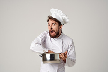 professional male chef in a restaurant with a saucepan in the hands of providing service