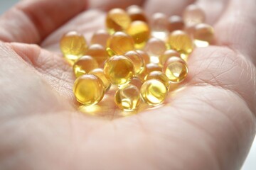 cod liver oil capsules vitamin in hand close up 