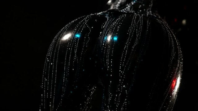 close-up of a swaying female ass in a black latex suit and streaked with white liquid on a dark background