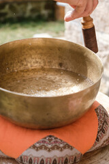 Tibetan singing bowl with water inside. Vertical photo.