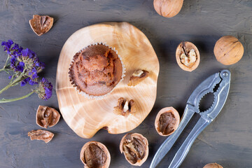  freshly baked golden cupcake with walnuts on a wooden serving board on a brown background. cracked walnuts. top view. a place to copy. The concept of nutrition. sweet homemade cakes. flat lay