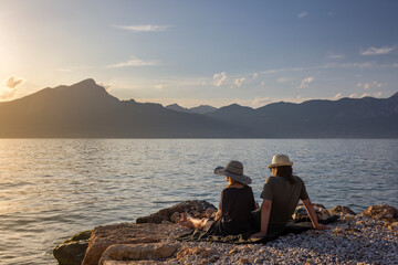 Italy - Lake Garda in the town of Torri del Benaco. A sunset, a romantic couple by the water, in...