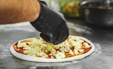 Closeup hand of chef baker making pizza at kitchen. The process of making pizza. cooking italian pizza