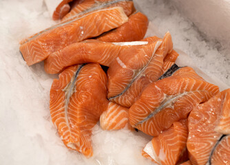Many Steaks of salmon lie on ice.